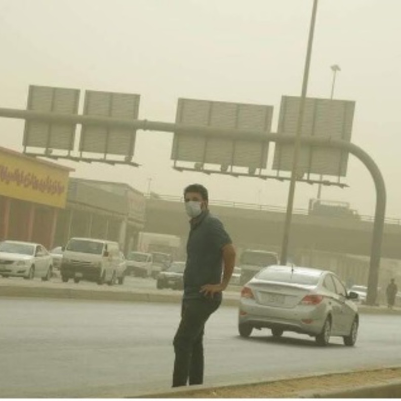 أحد المواطنين يحاول عبور الشارع وسط الغبار 