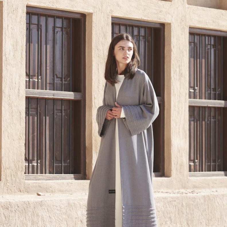 عباية رمادية مع اللمسات البيضاء من عفة الدباغ.