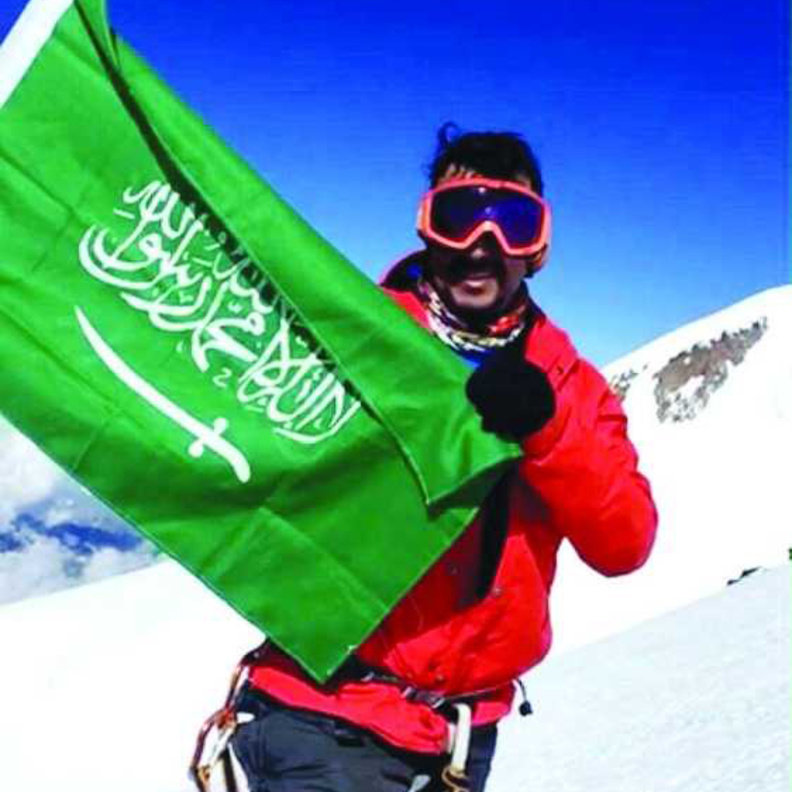 خالد الغامدي يرفع علم المملكة وعلم الرؤية 2030.