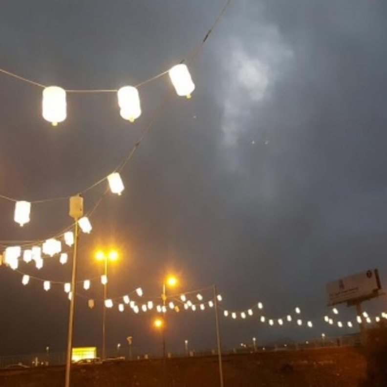 مشهد عرضي للكورنيش أثناء إضاءة الجراكن ليلا.