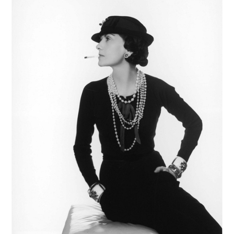 كوكو شانيل تقوم باضافة اللمسات النهائية على اطلالة عارضة الأزياء التي ترتدي طقم من التويد الشهير في المشغل الخاص بها عام ١٩٦٠