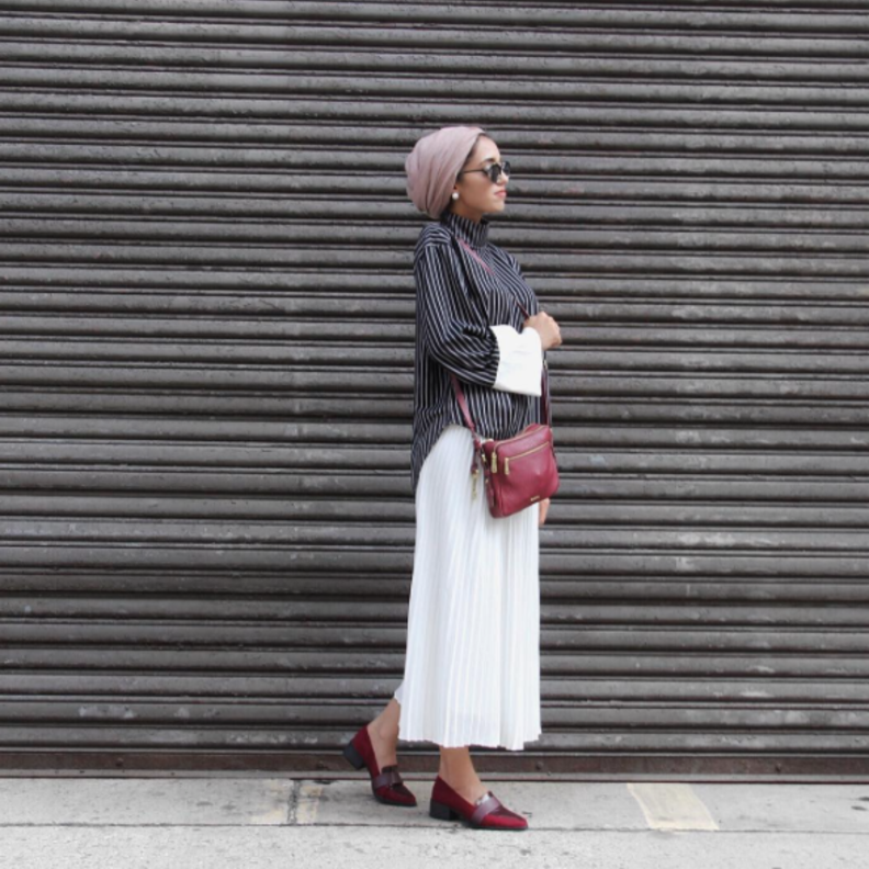أسلوب بسيط وأنيق بتنورة ماكسي بيضاء مع قميص ناعم وشنطة كتف وحذاء عملي بلون الأحمر القرمزي