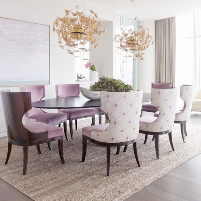 الكراسي باللون الزهري و التي تزود بأقمشة لستة منها و تبقي على الخشب في اثنين منها تعلوها جهازي إنارة من الفراشات الذهبية اللون 