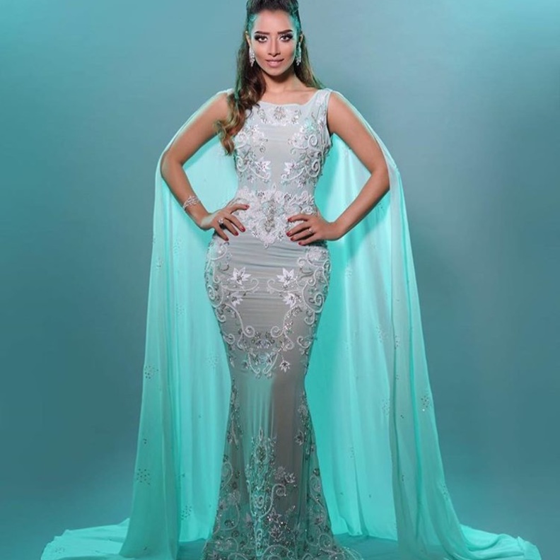 بلقيس فتحي مع المغني اندريا بوتشيلي في فستان ابيض بتنورة واسعة من الريش