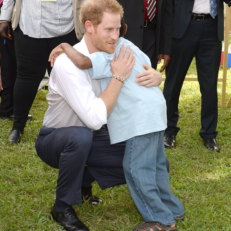 طفل صغير يعانق الامير هاري بحب وتقدير