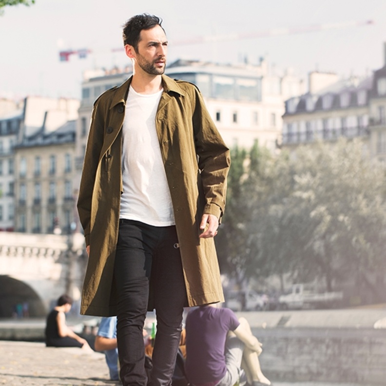 لوك شبابي مكوّن من ترانشكوت زيتي مع تيشرت أبيض وجينز أسود