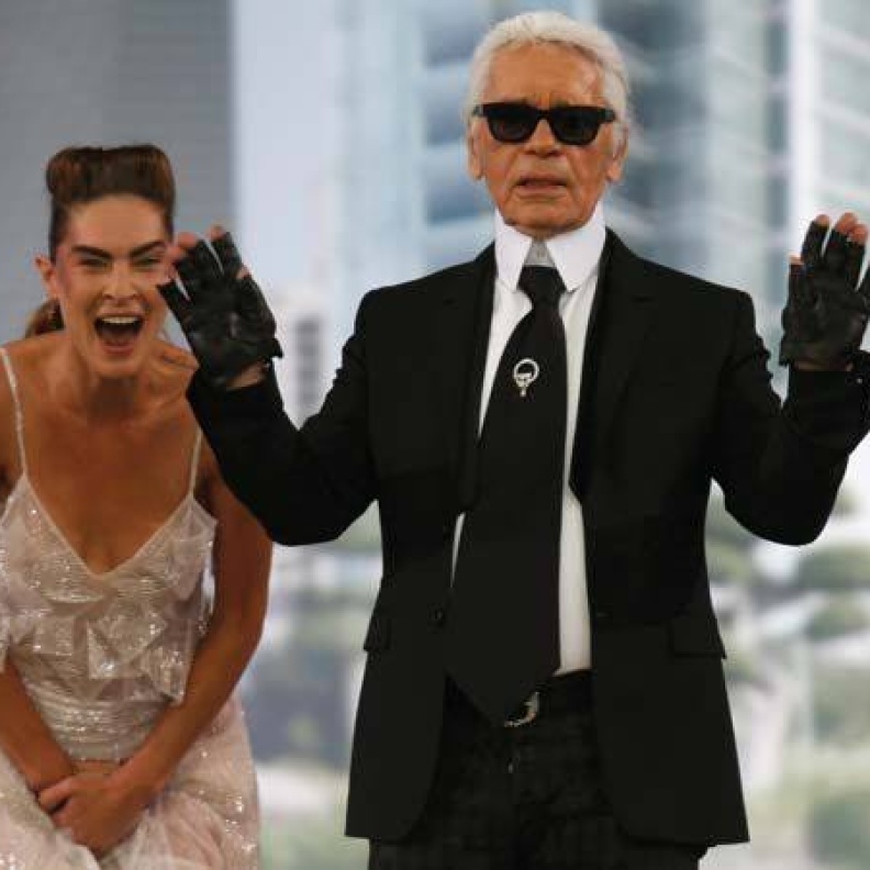 صورة مضحكة لعارضة تقف وراء كارل لاغرفيلد بعد انتهاء عرض شانيل