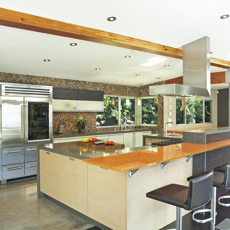 مطبخ عصري استعمل في صنعه الخشب من لونين و الحديد و رف مميز من الزجاج باللون البرتقالي