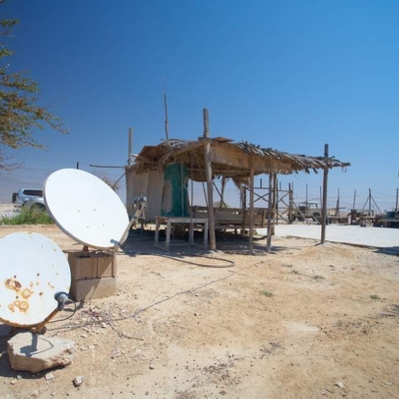 Rural communication through satellite dishes outside a dilapidated old dwelling
