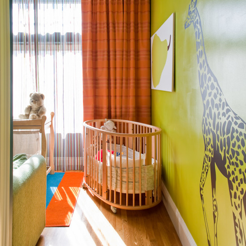 ركنة في غرفة لمولود صغير بطلاء ليموني وورق حائط على شكل زرافة