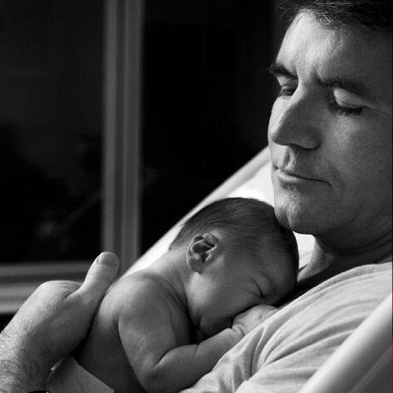  صورة تختصر كل حنان الأبو ة لسايمون كويل وهو يحتضن مولوده الجديد
