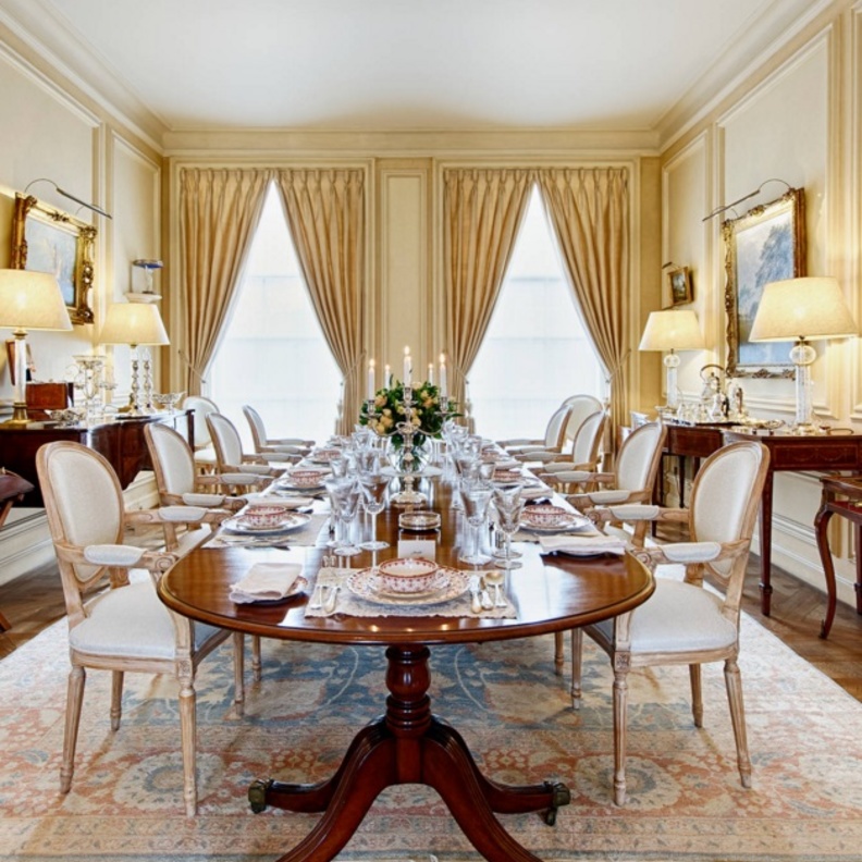 طاولة طعام كبيرة تعلوها إنارة كريستال تتدلى من السقف بشكل مميز