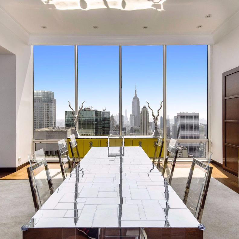 طاولة الطعام المميزة بالسطح العاكس و الكراسي الشفافة المحمولة على هيكل من الحديد  