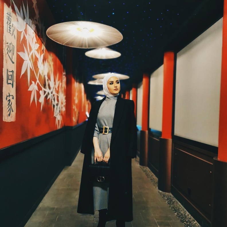 دلال الدوب بدت بغاية الأناقة بالفستان الرمادي الميدي مع المعطف الاسود الراقي