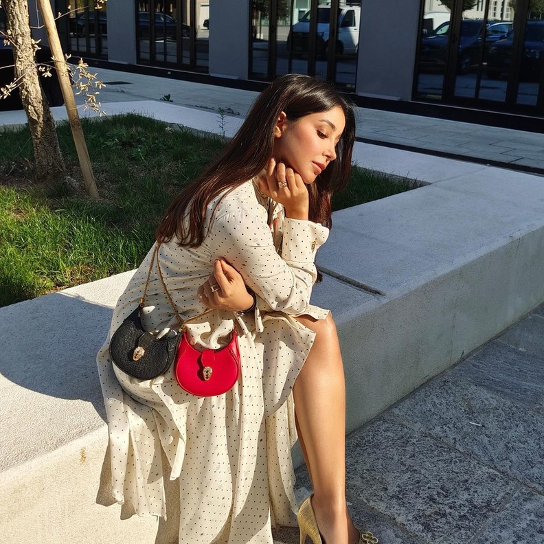 أطلت أسيل بفستان أبيض مزيّن بنقشة البولكا دوت من ماركة Fendi نسّقت معه حقيبة BVLGARI
