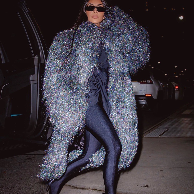 أطلت كيم بالمعطف الطويل مع الشراريب الفضية وتحته التوب الأسود والليغينغ الموصول بالجزمة