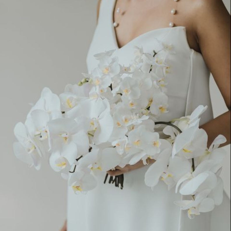 باقة زهور جذابة من زهور الأوركيد الأبيض وتعد خيار مثالي لعروس عصرية