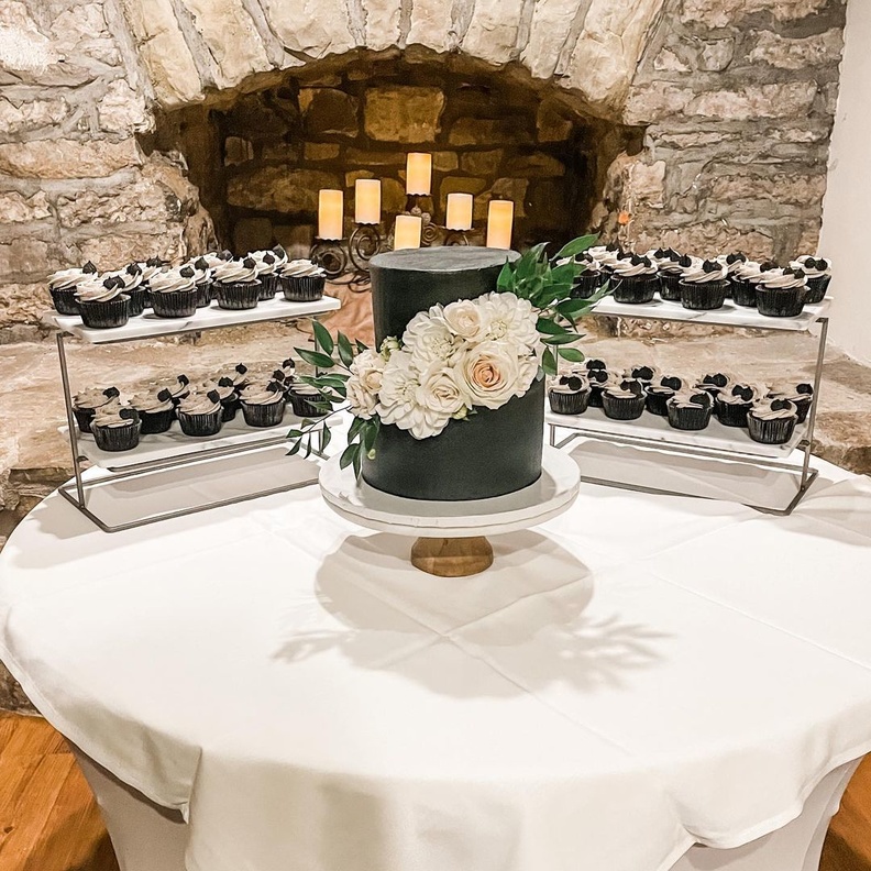 كعكة زفاف باللونين الأبيض والأسود تزينها أشكال فروع خضراء