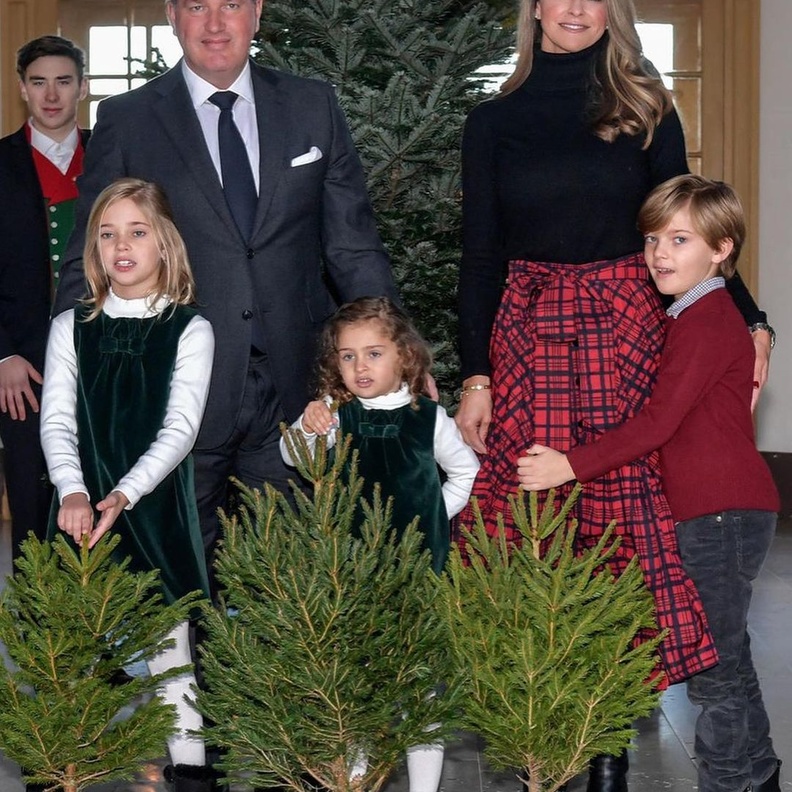 إختارت الكنزة السوداء ذات ياقة دائرية عالية مع تنورة ميدي باللون الأحمر مزيّنة بنقشة الترتان