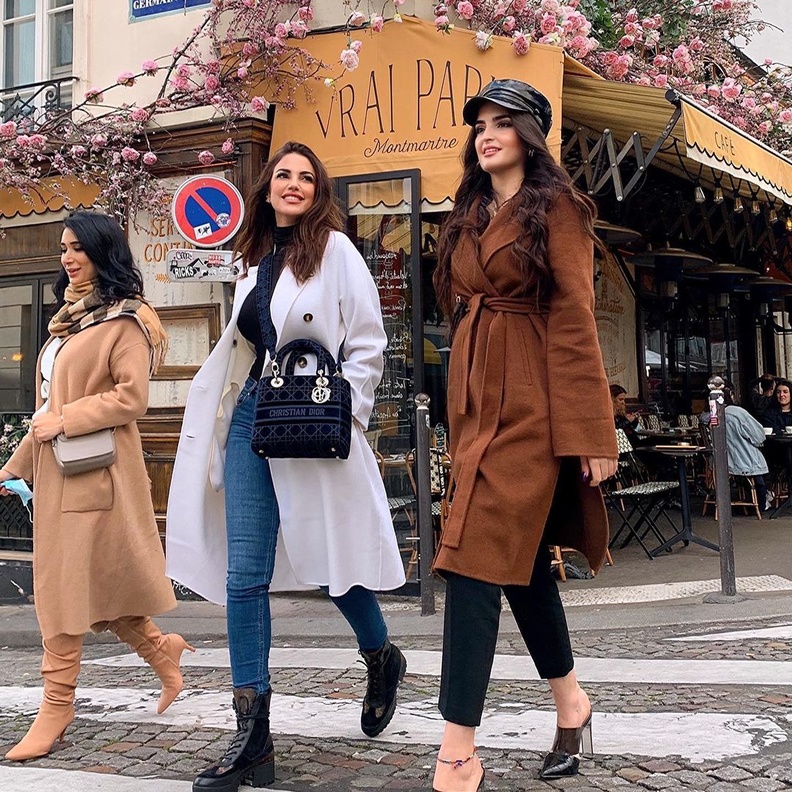 نسّقت الكنزة السوداء بياقة عالية مع البنطلون الدنيم وأكملت اللوك بمعطف أبيض