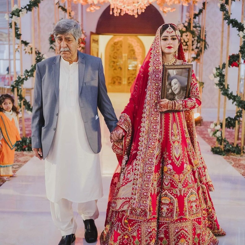 عروس تحمل صورة والدتها الراحلة في حفل زفافها