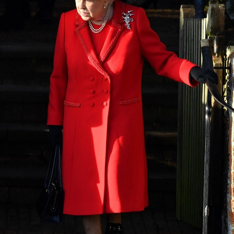 الملكة متألقة بالمعطف والفستان الأحمر