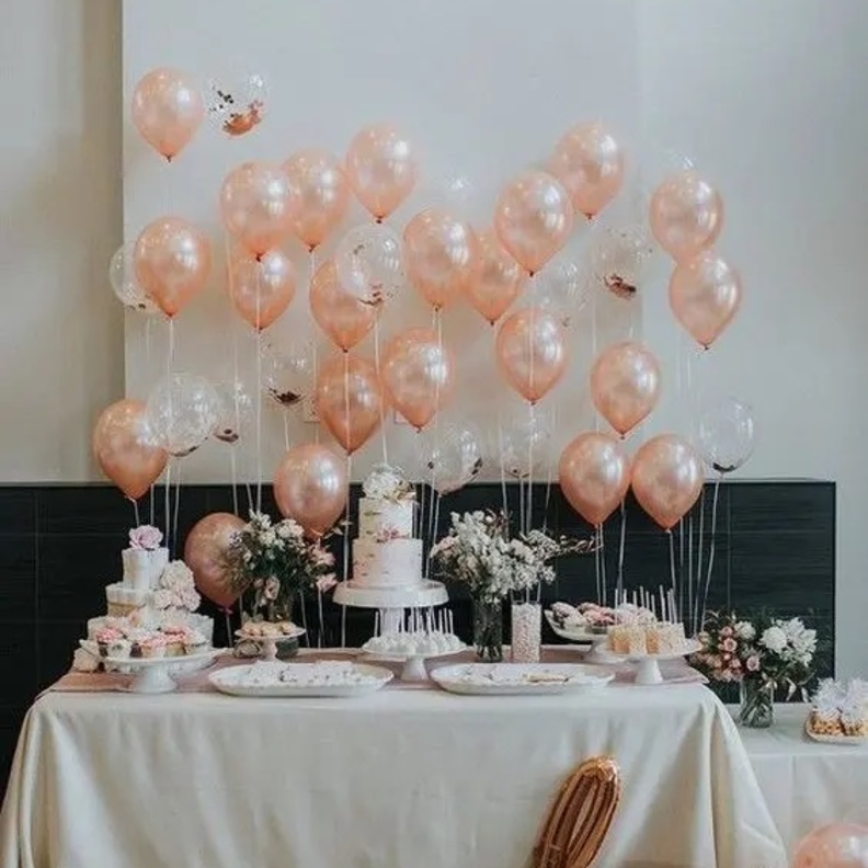 ديكور أنيق لطاولة زفاف بالبالونات البيضاء ونباتات الزينة الخضراء والزهور