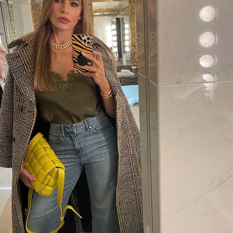 تألقت صوفيا بالبنطلون الدنيم مع التوب الستان والمعطف التويد الأنيق وبرزت حقيبة Bottega Veneta باللون الأصفر