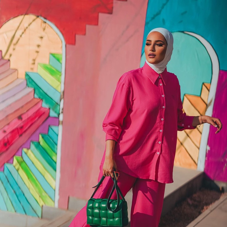 نسّقت دلال الدوب القميص الأوفر سايز مع البنطلون ذات القصة الواسعة وأكملت اللوك بحقيبة باللون الأخضر