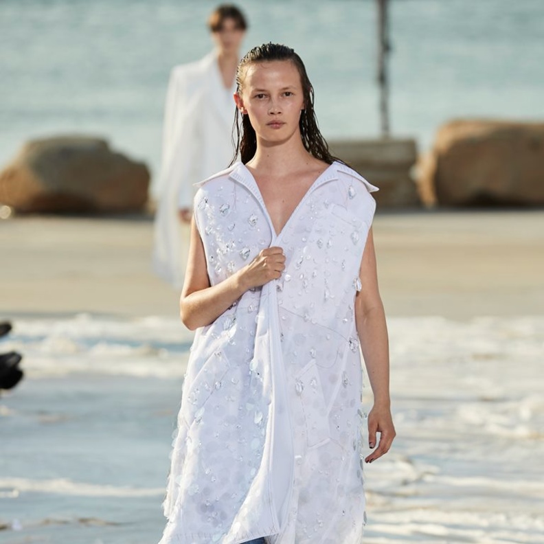 نسّقت دار Peter Do البنطلون الجينز الواسع مع الجاكيت الطويلة من دون أكمام ومزيّنة بالشكّ