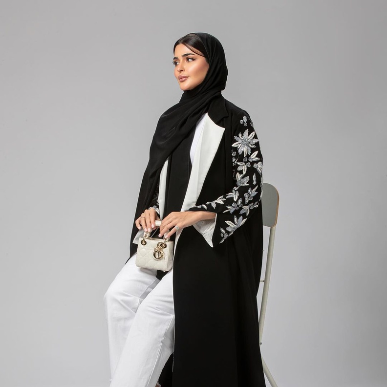 حنين الصيفي فبدت أنيقة وعصرية بجمعها بين العباية السوداء الطويلة والبنطلون الدنيم الأبيض