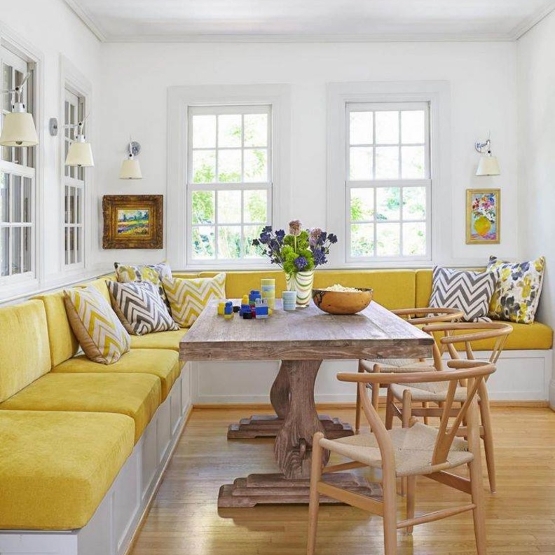 كنبة مطبخ بألوانة زاهية وطاولة وكراسي خشبية أنيقة