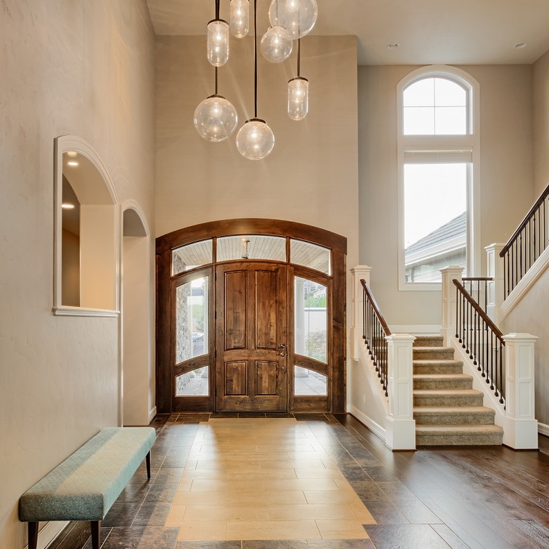 مدخل منزل مزين بمجموعة من الثريات الدائرية الرائعة