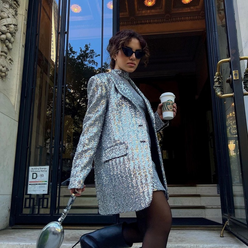 إطلالة نجود الرميحي تميّزت باللون الميتاليكي نسّقت الفستان مع الجاكيت الطويلة من مايكل كورس