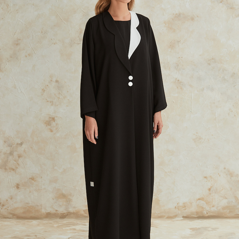 عباية سوداء بتفاصيل جذابة وشبابية بالقبّة باللونين الأسود مع الأزرار البارزة من WA Dubai 