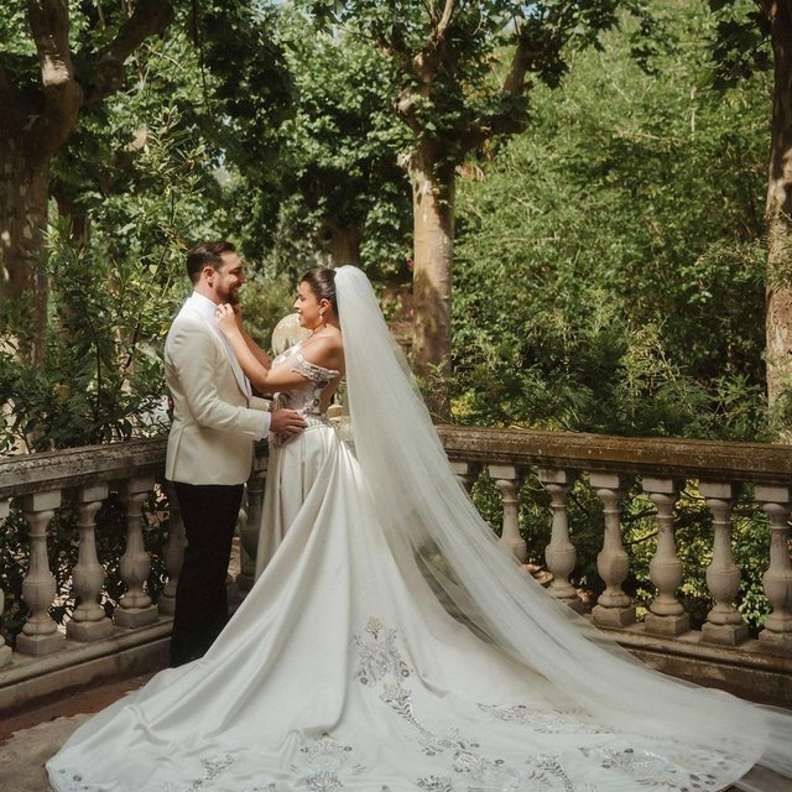 اختارت مينا الشيخلي فستان زفاف بقصة ملكية مع طرحة طويلة