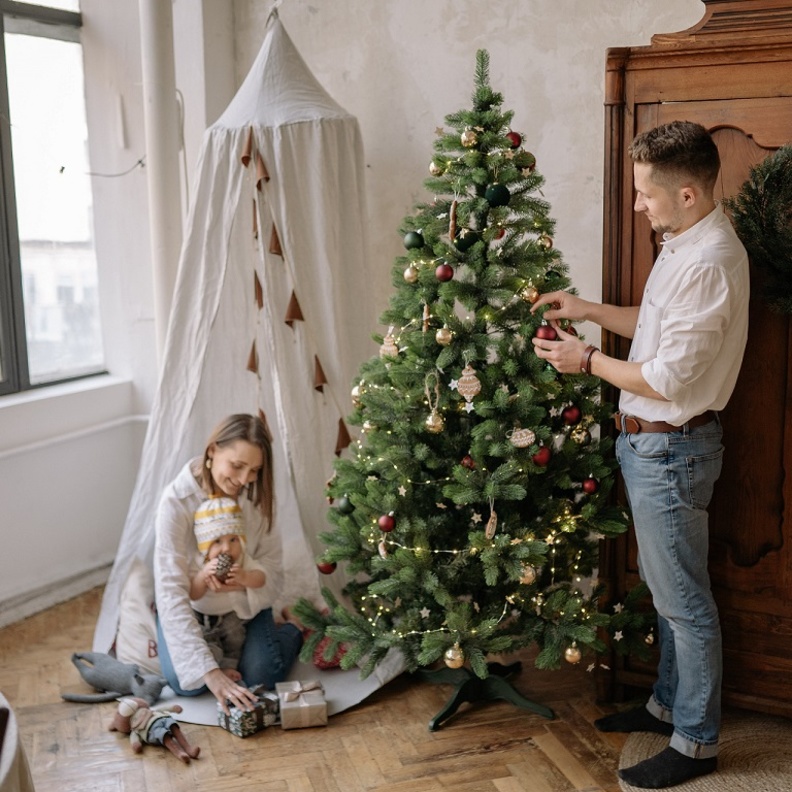 أسرة تقوم بتزيين شجرة عيد الميلاد