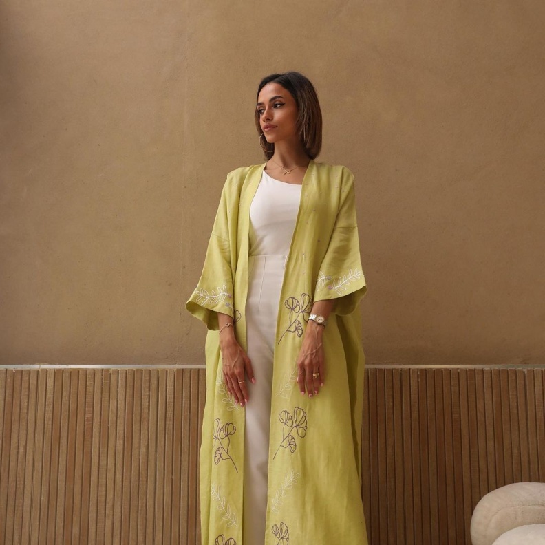 عباية صفراء بزهور بيضاء محددة على الأكمام تضفي لمسة من الرقي