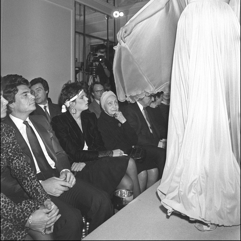 التقطت الصورة في 24 مارس 1985 في باريس لعارضة أزياء أثناء عرض مجموعة الملابس الجاهزة لخريف وشتاء، تحت أنظار المصممة الفرنسية مدام غراي (في الوسط)، في متجرها الواقع في شارع لا بيه في باريس. الصورة من موقع AFP