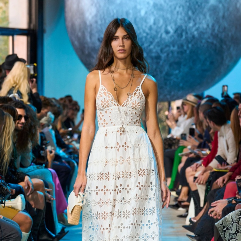 فستان أبيض بوهيمي وحقيبة من القش من مجموعة إيلي صعب ربيع صيف 2024