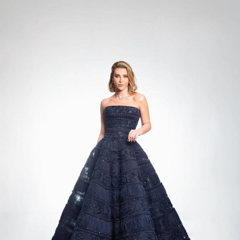 نور علي  بالفستان المنتفخ باللون الأزرق الداكن