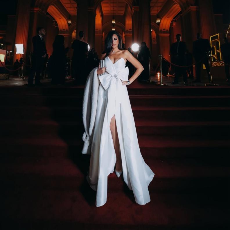 إلهام وجدي بفستان سهرة طويل باللون الأبيض مميز بقصة سترابلس