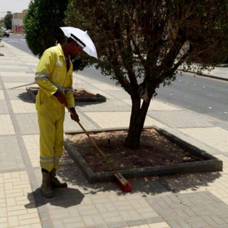عمال النظافة يرتدون المظلات الشمسية