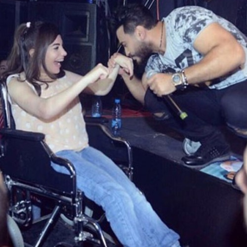 تامر حسني يقبل يد احدى المعجبات من ذوي الاحتياجات الخاصة