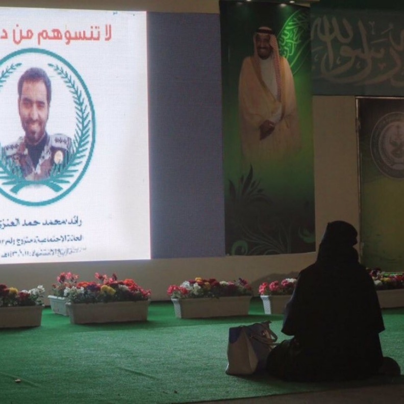 قريبة الشهيد محمد أحمد العنزي تجلس أمام صورته في الجنادرية