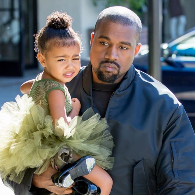 كاني يحمل ابنته وهو حزين