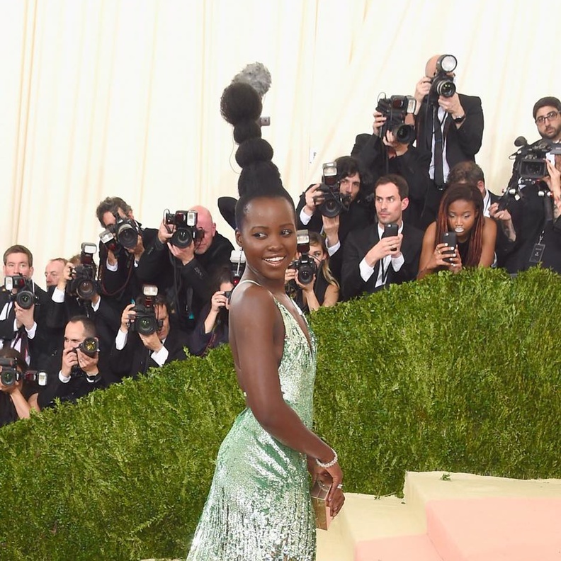 لوبيتا نيونغ تتحدى طول المايكرفون بتسريحتها الغريبة خلال حفل مت جالا في نيويورك أمس