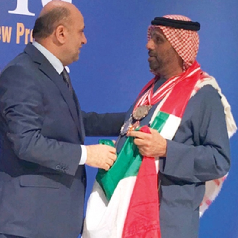 أحمد مجان المخترع الإماراتي متوشحاً بعلم وطنه الحبيب