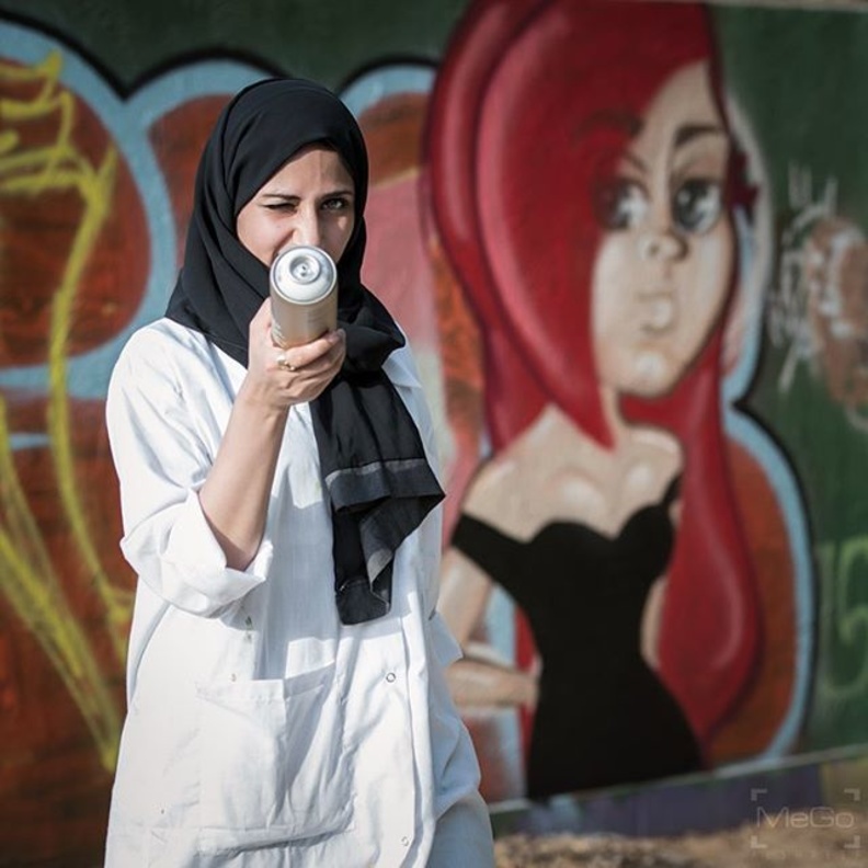 مريم مع جدارية من أعمالها 