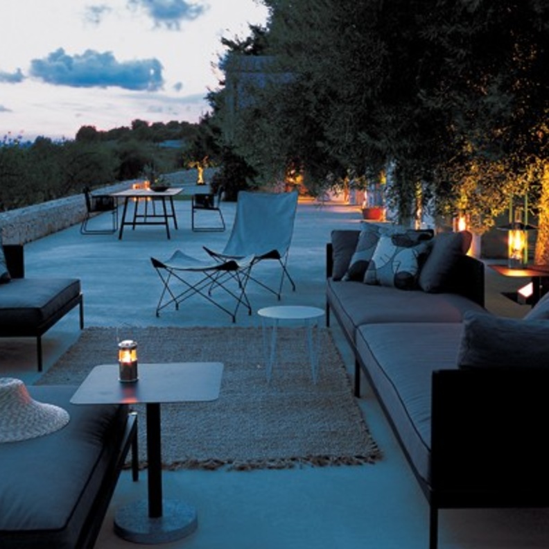 من تصميم Gordon Guillaumier، اخترنا لك جلسة خارجية مودرن بألوان داكنة لجلسة مسائية خاؤجية دافئة.